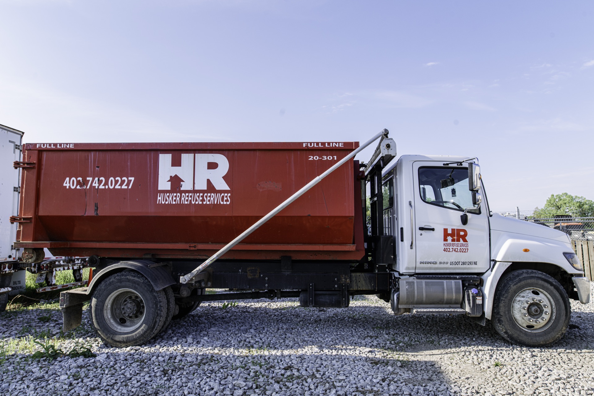 Husker Refuse roll-off dumpster delivery truck